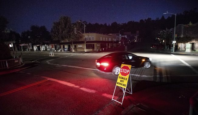 FILE - In this Oct. 10, 2019 file photo a car drives through a darkened Montclair Village as Pacific Gas &amp;amp; Electric power shutdowns continue in Oakland, Calif. Pacific Gas and Electric promised regulators Thursday, Aug. 13, 2020, that it has learned from its mishandling of deliberate blackouts and won&#x27;t disrupt as many people&#x27;s lives during the pandemic this year, when the utility expects to rely on outages to prevent its outdated grid from starting deadly fires. (AP Photo/Noah Berger, File)
