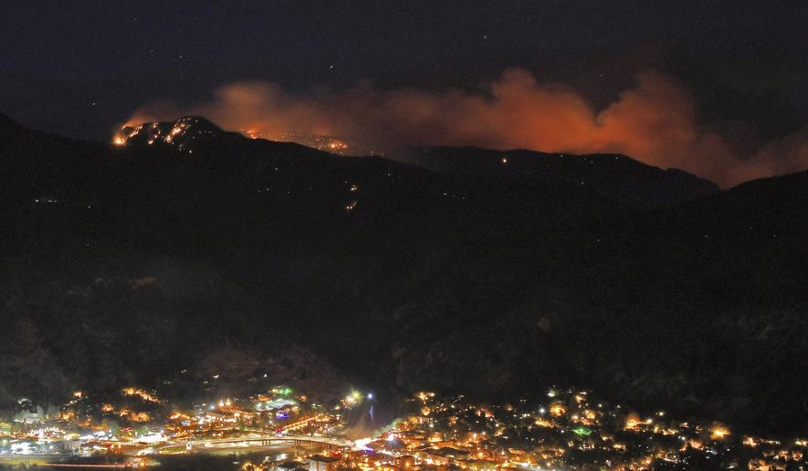 Embers from the Grizzly Creek Fire illuminate the mountains above Glenwood Springs, Colo., on the evening of Thursday, Aug. 13, 2020. Wildfires burning in western Colorado continue to grow in warm, windy weather, fueled by drought conditions. The Grizzly Creek Fire initially broke out along interstate 70 in Glenwood Canyon just east of Glenwood Springs. (Chelsea Self/Glenwood Springs Post Independent via AP)