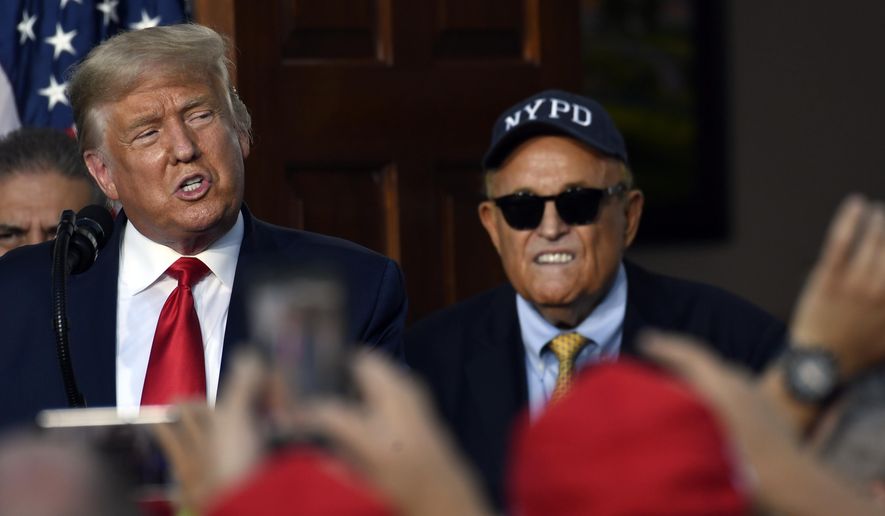 President Donald Trump speaks as Rudy Giuliani, an attorney for President Donald Trump watches, during an event Trump National Golf Club, Friday, Aug. 14, 2020, in Bedminster, N.J., with members of the City of New York Police Department Benevolent Association. (AP Photo/Susan Walsh)