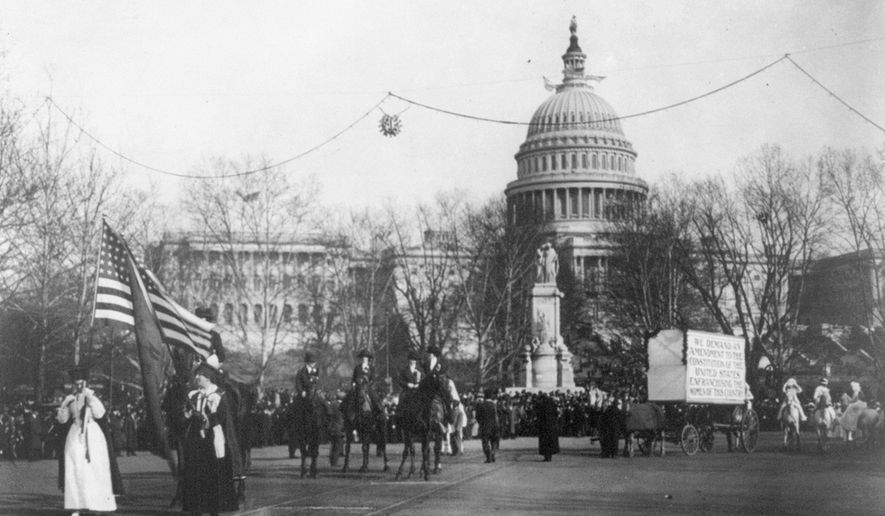 In this circa 1913 photo made available by the Library of Congress, demonstrators march in a women&#x27;s suffrage parade near the U.S. Capitol in Washington. A horse-drawn cart pulls a sign that reads, &amp;quot;We demand an amendment to the Constitution of the United States enfranchising the women of this country.&amp;quot; (Harris &amp;amp; Ewing/Library of Congress via AP)
