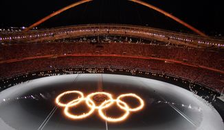 FILE - In this Aug. 13, 2004, file photo, the Olympic Rings are shown in flames in a pool of water during the Opening Ceremony of the 2004 Olympic Games in Athens. (AP Photo/Julie Jacobson, File)