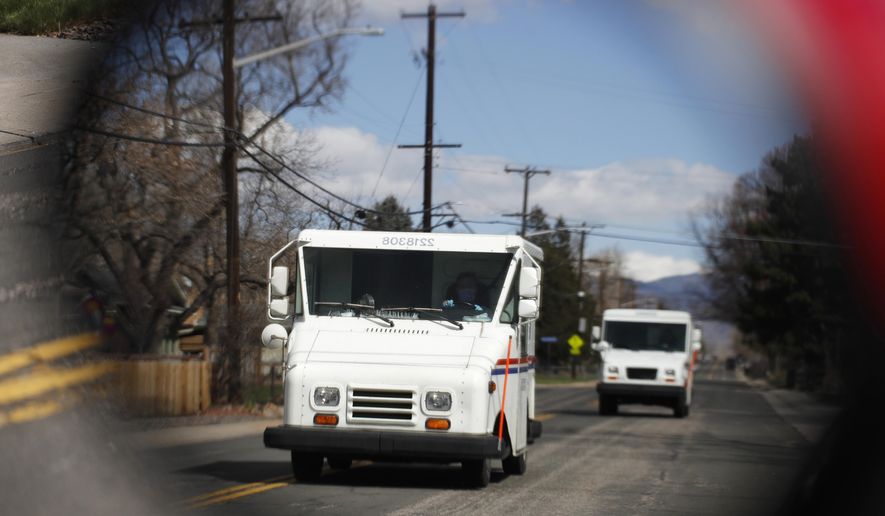 FILE - In this March 31, 2020, file photo United States Post Office delivery trucks are reflected in the side mirror of a vehicle as postal delivers set off on their daily rounds in Arvada, Colo. The U.S. Postal Service is warning states that it cannot guarantee all ballots cast by mail for the November election will arrive in time to be counted, even if mailed by state deadlines. (AP Photo/David Zalubowski, File)
