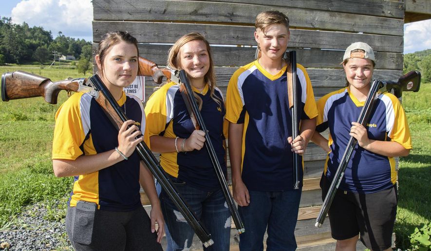 Scholastic Clay Target Program, team, former 4-H shooters, from left, Caytron Wykle, Lilly Goodwin, Evan Carter and Makayla Scott pose for a photograph on July 27, 2020 ,in Alvon, W.Va. Makayla Scott's father built a skeet range in their backyard and gathered a team of middle- and high-school shotgun enthusiasts to shoot there. It didn’t take them long to start winning medals. (John McCoy/Charleston Gazette-Mail via AP)