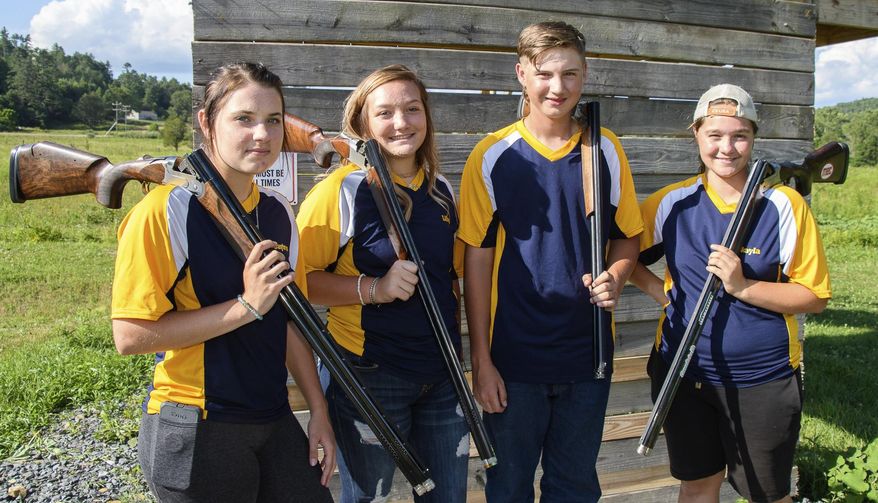Scholastic Clay Target Program, team, former 4-H shooters, from left, Caytron Wykle, Lilly Goodwin, Evan Carter and Makayla Scott pose for a photograph on July 27, 2020 ,in Alvon, W.Va. Makayla Scott's father built a skeet range in their backyard and gathered a team of middle- and high-school shotgun enthusiasts to shoot there. It didn’t take them long to start winning medals. (John McCoy/Charleston Gazette-Mail via AP)
