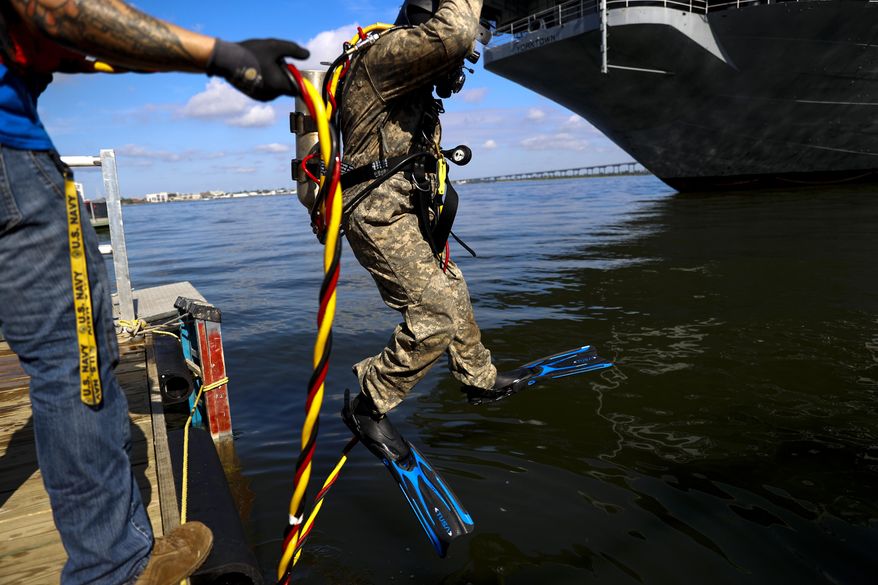 Jason Dayhuff a student with International Diving Institute in North Charleston dives to work on a vessel at Patriots Point Naval & Maritime Museum in Mount Pleasant, S.C., on Friday, Aug. 7, 2020. (Andrew J. Whitaker/The Post And Courier via AP)