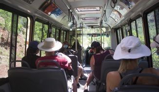 Visitors to Zion National Park, Utah ride a shuttle bus on Wednesday, July 1, 2020. Now two decades old, the buses are falling apart but there is no money to replace them. (K. Sophie Will/The Spectrum via AP)