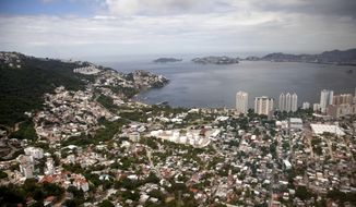 FILE - This Sept. 20, 2013 file photo shows an aerial view of the Pacific resort city of Acapulco, Mexico. Mexico’s Pacific coast resort of Acapulco expressed hope Friday, Aug. 14, 2020, for a return of tourists, as the number of new coronavirus cases drop and the violence that drove travelers away slowly declines. (AP Photo/Eduardo Verdugo, File)