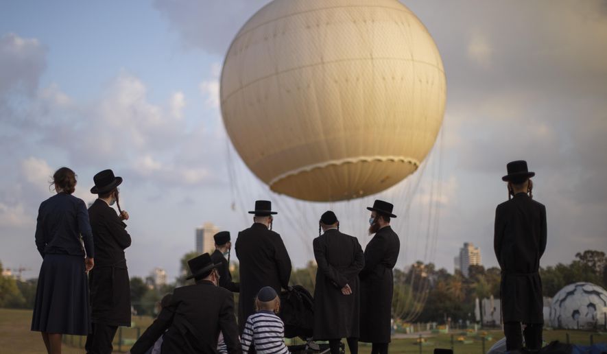 Ultra-Orthodox Jews, some wearing protective face masks amid concerns over the country's coronavirus outbreak, spend the day at a park in Tel Aviv, Israel, Wednesday, Aug. 12, 2020. Ultra-Orthodox Yeshivas students enjoy Bein Hazmanim ("between the times") for two weeks of summer vacation. (AP Photo/Oded Balilty)