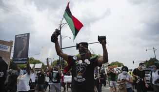 About 200 anti-police brutality protesters march in the neighborhood of Bronzeville, in Chicago, Saturday, Aug. 15, 2020. Protesters walked from Bronzeville to Grant Park, after police prohibited them from marching along the Dan Ryan Expressway. (Pat Nabong/Chicago Sun-Times via AP)