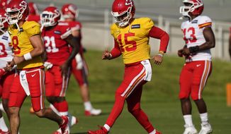 Kansas City Chiefs quarterback Patrick Mahomes (15) runs with teammates during an NFL football training camp Saturday, Aug. 15, 2020, in Kansas City, Mo. (AP Photo/Charlie Riedel)