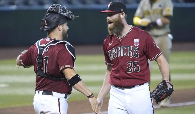 Arizona Diamondbacks pitcher Archie Bradley, right, and Stephen Vogt, left, celebrate after defeating the San Diego Padres in a baseball game, Sunday, Aug 16, 2020, in Phoenix. (AP Photo/Rick Scuteri)