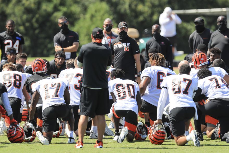 Cincinnati Bengals' head coach Zac Taylor, center, talks with his team after an NFL football camp practice in Cincinnati, Monday, Aug. 17, 2020. (AP Photo/Aaron Doster)