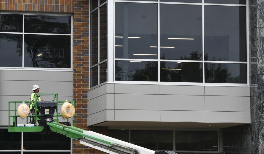 Work continues at the site of the new Cathedral High School academic building Monday, Aug. 10, 2020, in St. Cloud, Minn. “This new building is coming at the perfect time to be able to give Cathedral extra space. The whole idea of this building was to be able to have flexible space, more collaboration space, room to spread out,” said Marit Ortega, director for the Campaign for Cathedral. (Dave Schwarz/St. Cloud Times via AP)