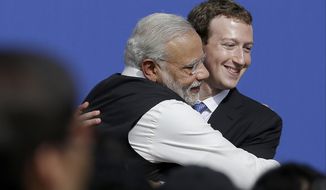 FILE - In this Sept. 27, 2015, file photo, Facebook CEO Mark Zuckerberg, right, hugs Prime Minister of India Narendra Modi at Facebook in Menlo Park, Calif. Members of India&#39;s governing party on Monday rejected allegations that Facebook had chosen to turn a blind eye to partisan hate speech on its platform to protect its growing business interests in India. As usage has spread across India, Facebook and its subsidiary WhatsApp have become fierce battlegrounds for India’s political parties, but spokesmen for Prime Minister Narendra Modi’s Bharatiya Janata Party denied a newspaper report that asserted Facebook officials chose not to take action against party members whose posts violated rules against hate speech. (AP Photo/Jeff Chiu, File)
