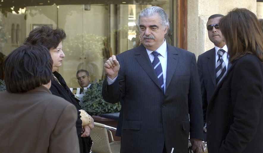 In this Feb. 14, 2005, file photo, former Lebanese Prime Minister Rafik Hariri, center, speaks to people outside the Lebanese Parliament minutes before an explosion killed him and 22 others, in Beirut, Lebanon. More than 15 years after the truck bomb assassination of Hariri in Beirut, a U.N.-backed tribunal in the Netherlands is announcing verdicts this week in the trial of four members of the militant group Hezbollah allegedly involved in the killing. (AP Photo, File)