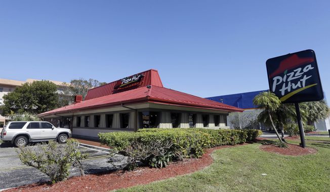 FILE- This Jan. 24, 2017, file photo shows a Pizza Hut in Miami. Pizza Hut has reached an agreement with one of its largest franchisees to close 300 underperforming U.S. restaurants. NPC International, a Leawood, Kansas-based franchisee, announced the agreement Monday, Aug. 17, 2020, in a bankruptcy court filing.  (AP Photo/Alan Diaz, File)