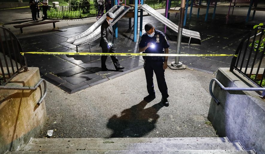 Police officers search a playground for evidence at a crime scene where two individuals were injured by gunshots on Atlantic Avenue, Saturday, July 18, 2020, in the Brooklyn borough of New York. President Donald Trump is again threatening to send federal agents to New York City if local authorities don&#x27;t stop a surge of violence that has left seven people dead and more than 50 people shot since Friday, Aug. 14. (AP Photo/John Minchillo) **FILE**