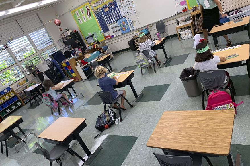 In this photo provided by Keoki Fraser, a small group of kindergarteners sits spaced apart in a classroom at Aikahi Elementary School in Kailua, Hawaii on Monday, Aug. 17, 2020. (Keoki Fraser via AP) **FILE**