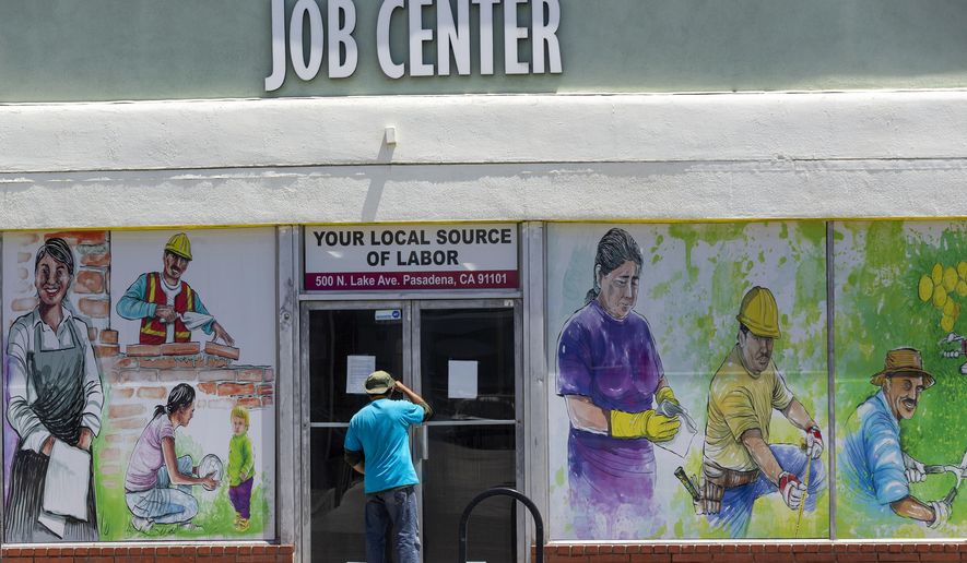 In this May 7, 2020, file photo, a person looks inside the closed doors of the Pasadena Community Job Center in Pasadena, Calif., during the coronavirus outbreak. (AP Photo/Damian Dovarganes, File)