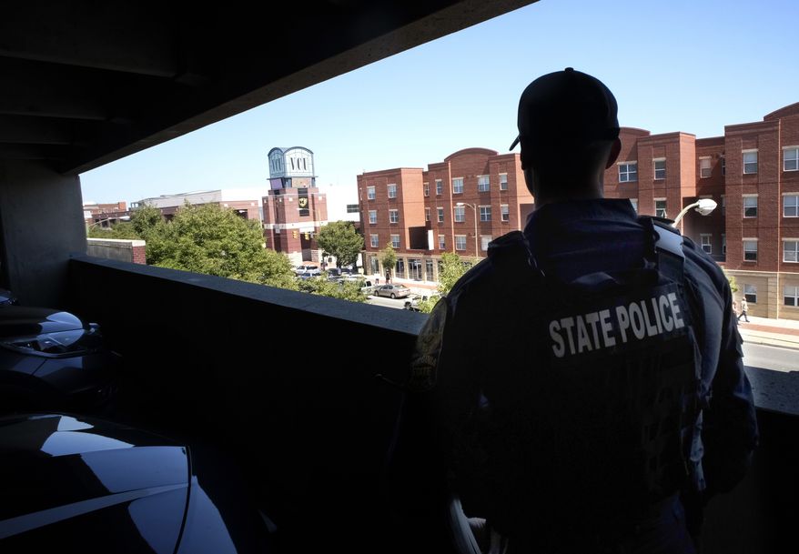 A Virginia State Trooper stands in a parking deck overlooking the Siegel Center in Richmond, Va., where the Virginia House of Delegates is meeting Tuesday, August 18, 2020. (Bob Brown/Richmond Times-Dispatch via AP)