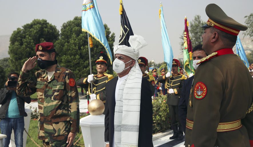 Afghan President Ashraf Ghani sings the national anthem after laying flowers on the Independence Minaret monument during the Independence Day celebrations at the Defense Ministry in Kabul, Afghanistan, Tuesday, Aug. 18, 2020. (AP Photo/Rahmat Gul)