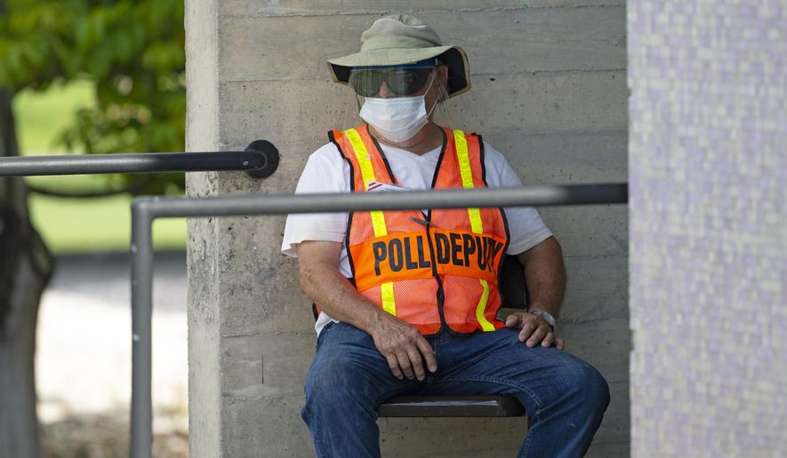 A polling worker waits outside the polling place during early voting for primary election at the Miami Dade College North Campus located at 11380 NW 27th Avenue in Miami on Sunday, August 9, 2020. (David Santiago/Miami Herald via AP)