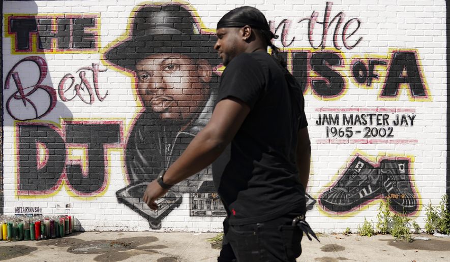 A pedestrian passes a mural of rap pioneer Jam Master Jay of Run-DMC by artist Art1Airbrush, Tuesday, Aug. 18, 2020, in the Queens borough of New York. Charges against two individuals in the hip hop artist's almost 18-year-old murder case were announced the previous day. (AP Photo/John Minchillo)