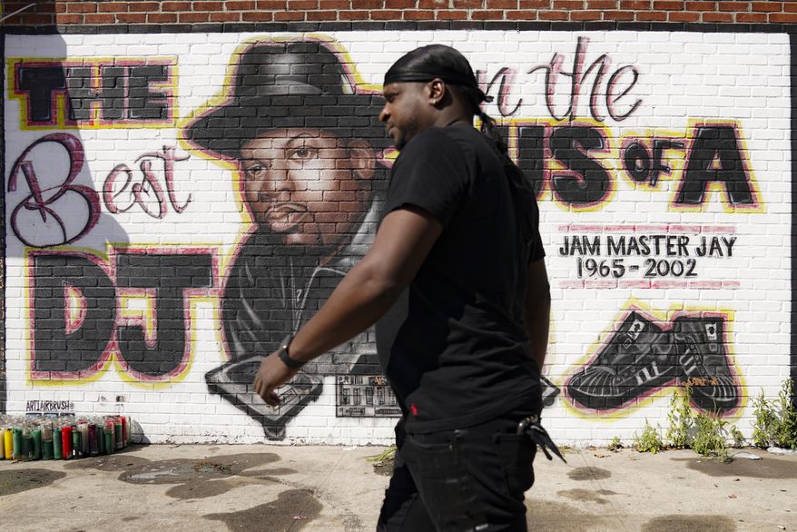 A pedestrian passes a mural of rap pioneer Jam Master Jay of Run-DMC by artist Art1Airbrush, Tuesday, Aug. 18, 2020, in the Queens borough of New York. Charges against two individuals in the hip hop artist's almost 18-year-old murder case were announced the previous day. (AP Photo/John Minchillo)