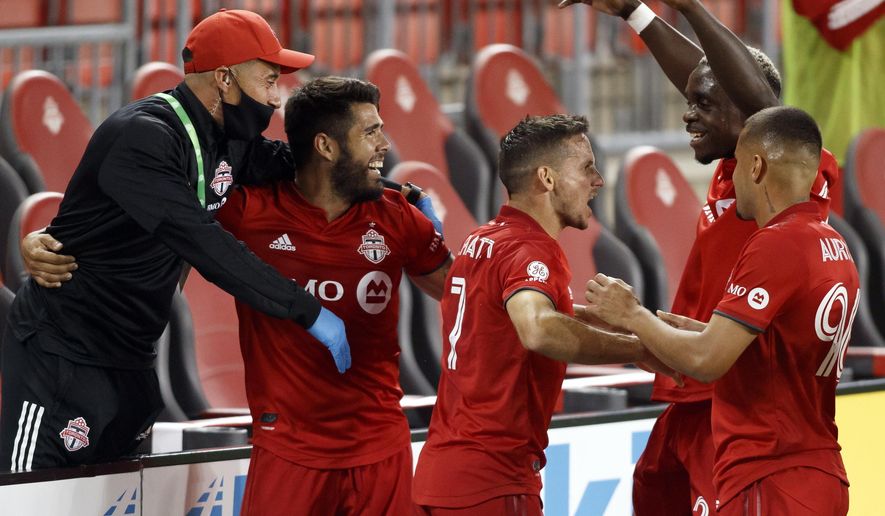 Toronto FC forward Pablo Piatti (7) celebrates his goal alongside team-mates midfielder Alejandro Pozuelo (10), Toronto FC midfielder Richie Laryea (22), and Toronto FC defender Auro (96) during first half MLS soccer action against the Vancouver Whitecaps at BMO field in Toronto, Tuesday, Aug. 18, 2020. (Cole Burston/The Canadian Press via AP)