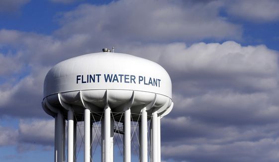 In this March 21, 2016, file photo, the Flint Water Plant water tower is seen in Flint, Mich. Multiple news outlets report Wednesday, Aug. 19, 2020, that the state of Michigan has reached a $600 million agreement to compensate Flint residents whose health was damaged by lead-tainted drinking water. (AP Photo/Carlos Osorio, File)