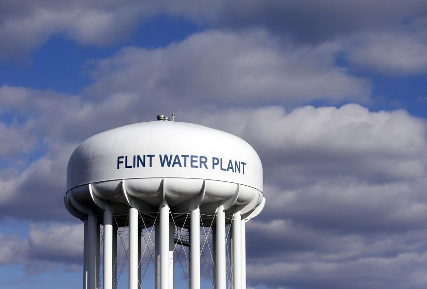 In this March 21, 2016, file photo, the Flint Water Plant water tower is seen in Flint, Mich. Multiple news outlets report Wednesday, Aug. 19, 2020, that the state of Michigan has reached a $600 million agreement to compensate Flint residents whose health was damaged by lead-tainted drinking water. (AP Photo/Carlos Osorio, File)