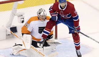 Montreal Canadiens centre Jesperi Kotkaniemi (15) leaps to try to deflect a shot in front of Philadelphia Flyers goaltender Carter Hart (79) during third period NHL Eastern Conference Stanley Cup first round playoff hockey action in Toronto, Tuesday, Aug. 18, 2020. (Frank Gunn/The Canadian Press via AP)