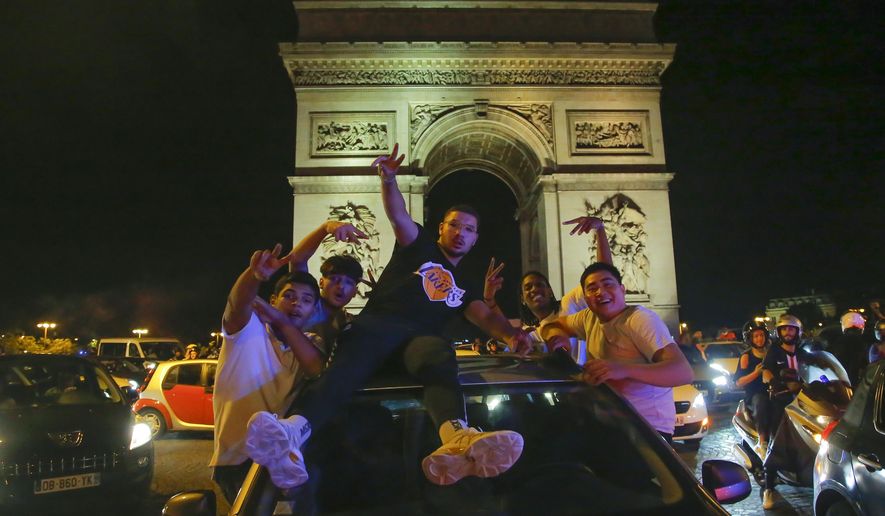 Supporters of the Paris Saint Germain soccer team celebrates on the Champs Elysee in Paris, Tuesday, Aug. 18, 2020 after his team won 3-0 against RB Leipzig. (AP Photo/Michel Euler)