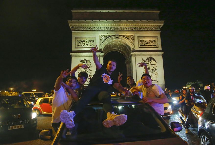 Supporters of the Paris Saint Germain soccer team celebrates on the Champs Elysee in Paris, Tuesday, Aug. 18, 2020 after his team won 3-0 against RB Leipzig. (AP Photo/Michel Euler)