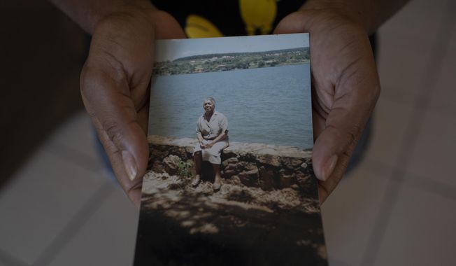 Reginalda Oliveira Costa, shows a photo of her mother, Carivaldina Oliveira da Costa, or &amp;quot;Aunt Uia&amp;quot; in Rasa quilombo in Buzios, Brazil, Sunday, July 12, 2020. Carivaldina was the matriarch of the Rasa quilombo on the northern coast of Rio de Janeiro state. The woman known as Tia Uia has often been described as a &amp;quot;living library&amp;quot; – the keeper of the community&#x27;s stories and customs who could recall the days before Buzios became an elite seaside getaway, and who fought for the rights of those living in quilombos. She died of COVID-19 last month, aged 78. (AP Photo/Silvia Izquierdo)