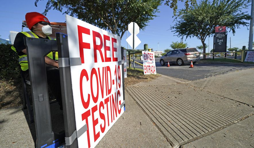 A healthcare worker sits at the entrance to a free COVID-19 testing site at Minute Maid Park Wednesday, Aug. 19, 2020, in Houston. (AP Photo/David J. Phillip)