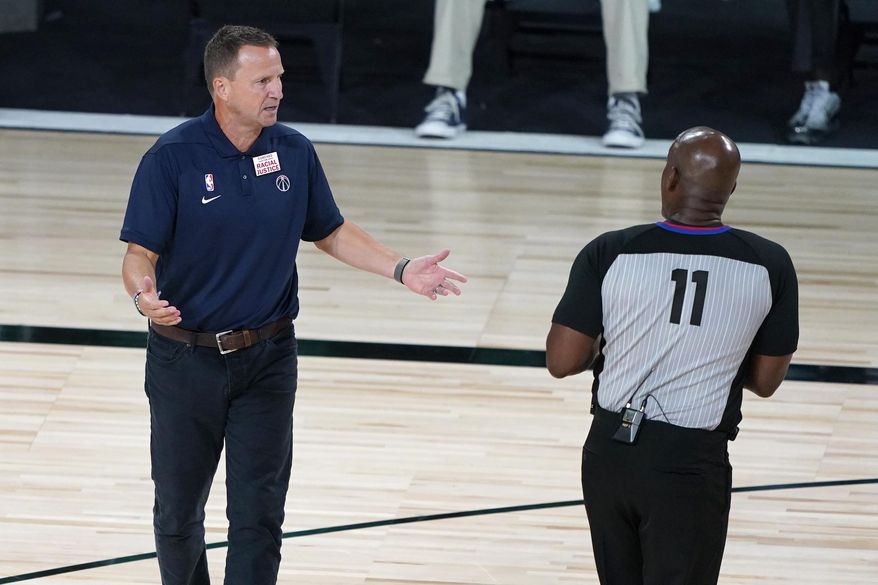 Washington Wizards head coach Scott Brooks talks with referee Derrick Collins (11) during the second half of an NBA basketball game between the Boston Celtics and the Washington Wizards Thursday, Aug. 13, 2020 in Lake Buena Vista, Fla. (AP Photo/Ashley Landis, Pool)  **FILE**