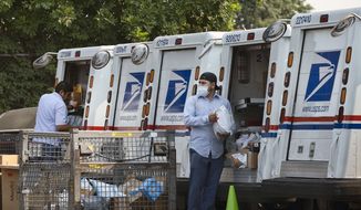 In this file photo, postal workers load packages in their mail delivery vehicles at the Panorama City Post Office on Thursday, Aug. 20, 2020, in the Panorama City section of Los Angeles. (AP Photo/Richard Vogel)  **FILE**
