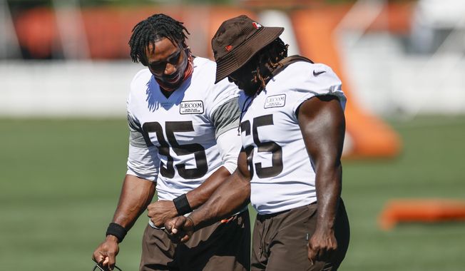 Cleveland Browns defensive end Myles Garrett (95) and defensive tackle Larry Ogunjobi (65) walk across the field during practice at the NFL football team&#x27;s training facility Thursday, Aug. 20, 2020, in Berea, Ohio. (AP Photo/Ron Schwane)