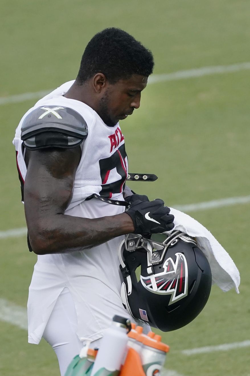 Atlanta Falcons safety Keanu Neal (22) cleans his face shield during an NFL training camp football practice Thursday, Aug. 20, 2020, in Flowery Branch, Ga. (AP Photo/John Bazemore, Pool)