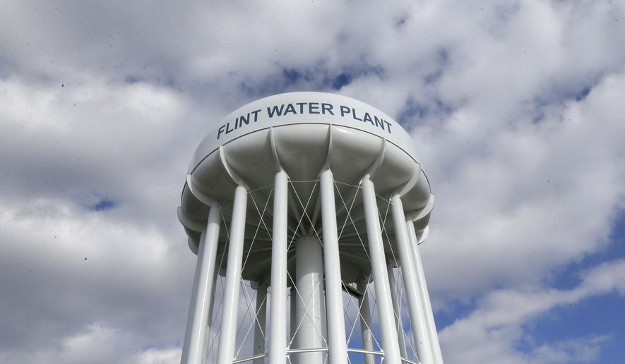 FILE - In this March 21, 2016, file photo, the Flint Water Plant water tower is seen in Flint, Mich. Michigan Gov. Gretchen Whitmer says a proposed $600 million deal between the state of Michigan and Flint residents harmed by lead-tainted water is a step toward making amends. Officials announced the settlement Thursday, Aug. 20, 2020, which must be approved by a federal judge. (AP Photo/Carlos Osorio, File)