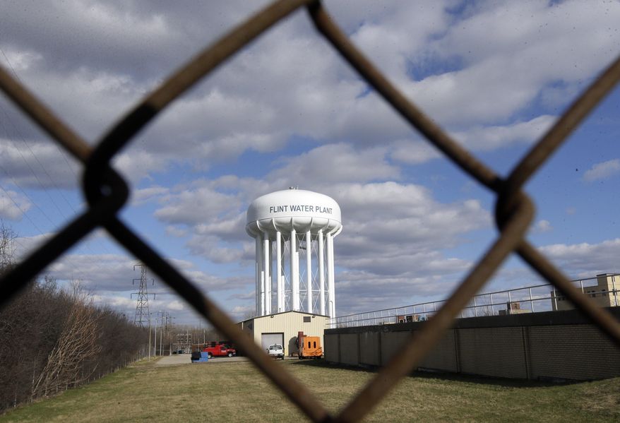 FIL - In this March 21, 2016, file photo the Flint Water Plant water tower is seen in Flint, Mich. Michigan Gov. Gretchen Whitmer says a proposed $600 million deal between the state of Michigan and Flint residents harmed by lead-tainted water is a step toward making amends. Officials announced the settlement Thursday, Aug. 20, 2020, which must be approved by a federal judge. (AP Photo/Carlos Osorio, File)