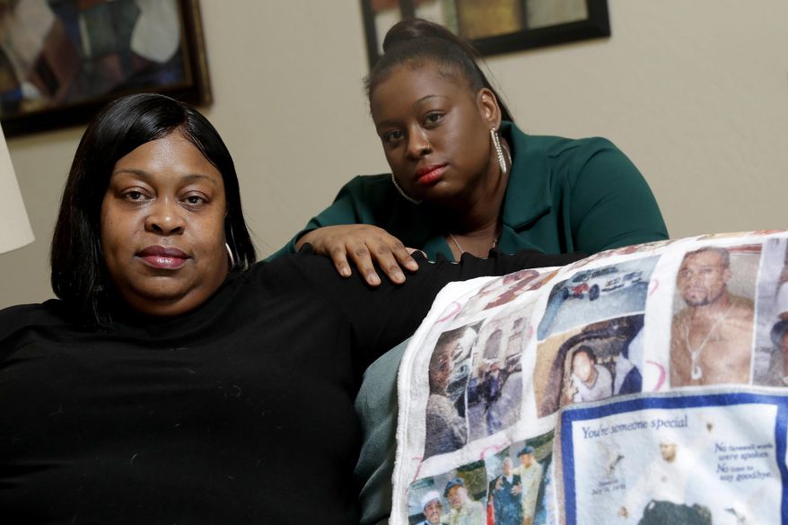 FILE - In this June 5, 2020, file photo, Mussallina Muhaymin, left, and Zarinah Tavares, sisters of Muhammad Abdul Muhaymin Jr., a homeless man who died while in Phoenix police custody, pose in Phoenix. An advocacy group released what they say is previously unseen body camera footage Thursday, Aug. 20 showing Phoenix police mocking the religion of the Muslim man who later died in their custody. Muslim Advocates, a national civil rights organization, released video from the 2017 death of Muhaymin in which he can be heard crying out in pain and calling for Allah, the Arabic word for God. (AP Photo/Matt York, File)