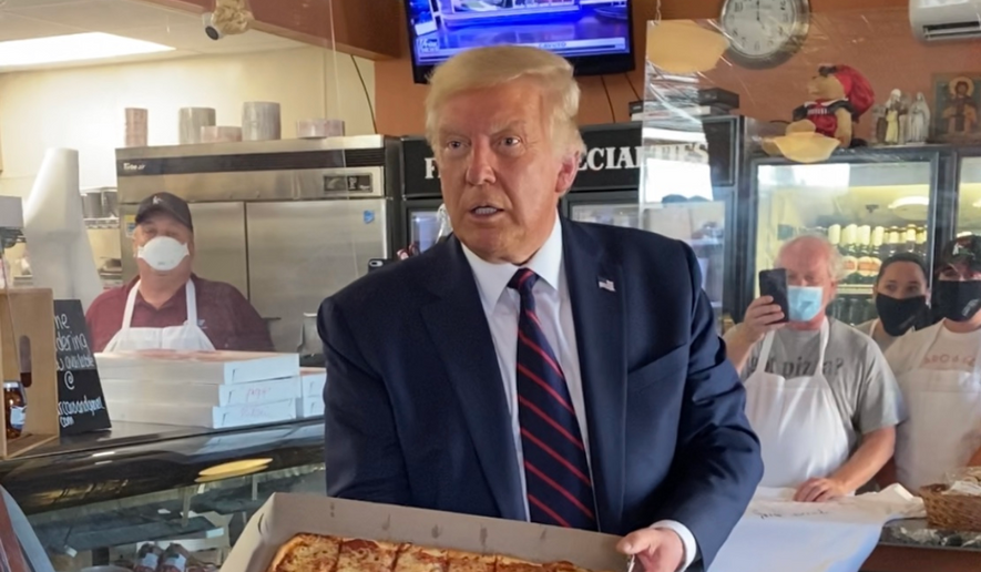 President Trump shows off a pizza pie he ordered while making a quick stop off his motorcade route in Pennsylvania on Thursday, Aug. 20, 2020. (Tom Howell/The Washington Times)