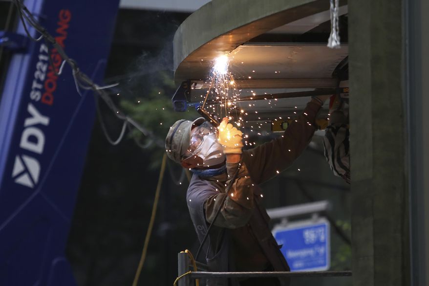 A worker wearing a face mask to help protect against the spread of the coronavirus welds at a construction site in Seoul, South Korea, Friday, Aug. 21, 2020. (AP Photo/Ahn Young-joon)
