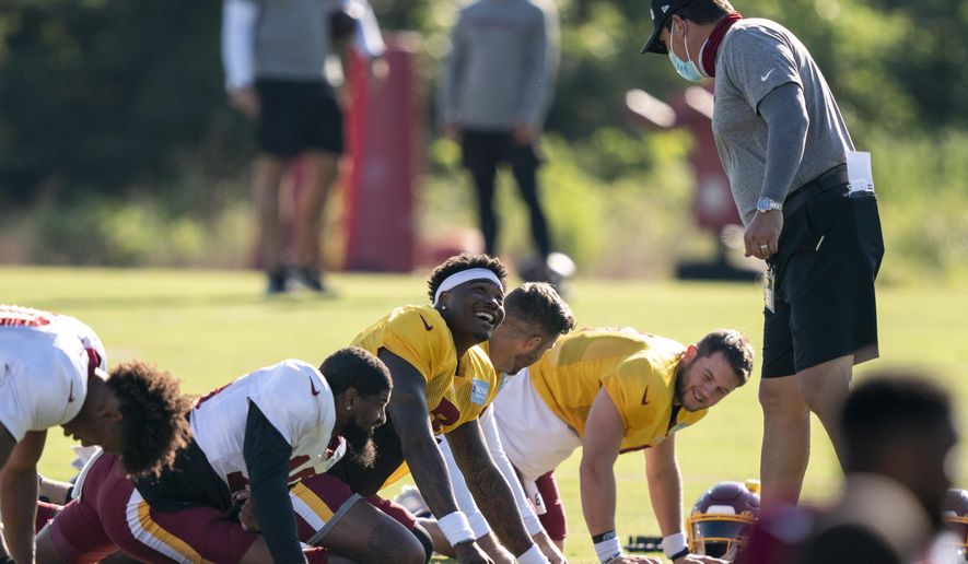 Washington quarterbacks Dwayne Haskins Jr., third from left, Alex Smith, and Kyle Allen, rear, talk with head coach Ron Rivera right, during practice at the team&#39;s NFL football training facility, Tuesday, Aug. 18, 2020, in Ashburn, Va. (AP Photo/Alex Brandon)
