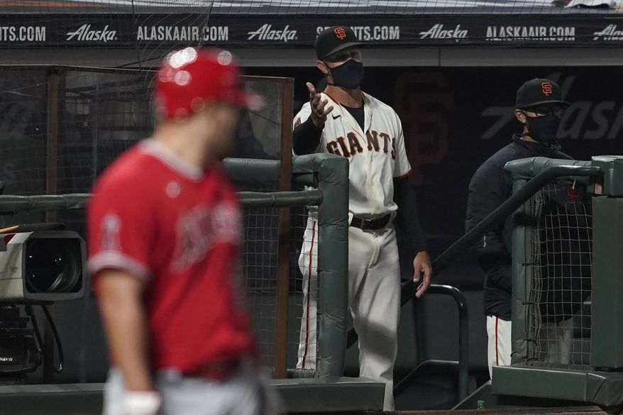 San Francisco Giants manager Gabe Kapler gestures toward umpires as Los Angeles Angels&#39; Mike Trout, left, stands at the plate during the seventh inning of a baseball game in San Francisco, Thursday, Aug. 20, 2020. (AP Photo/Jeff Chiu)