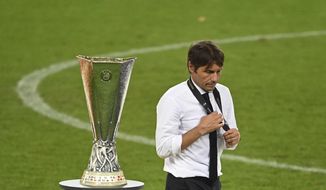 Inter Milan&#39;s head coach Antonio Conte walks past the trophy after the Europa League final soccer match between Sevilla and Inter Milan in Cologne, Germany, Friday, Aug. 21, 2020. (Ina Fassbender/Pool via AP)