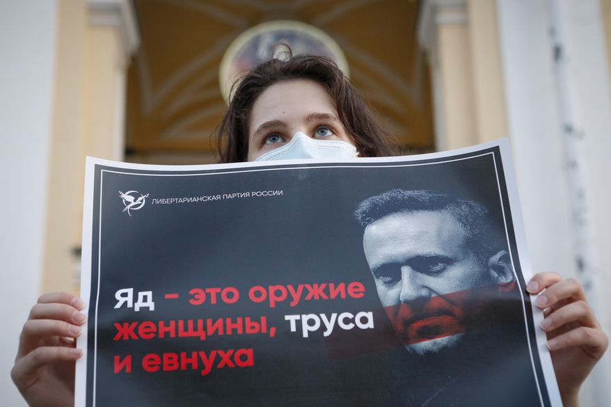 A protester stands holds a poster reads &amp;quot;poison is the weapon of a woman, a coward and a eunuch!&amp;quot; during a picket in support of Russian opposition leader Alexei Navalny in the center of St. Petersburg, Russia, Thursday, Aug. 20, 2020. Russian opposition politician Alexei Navalny is on a hospital ventilator in a coma, after falling ill from a suspected poisoning, according to his spokeswoman Kira Yarmysh. (AP Photo/Elena Ignatyeva)