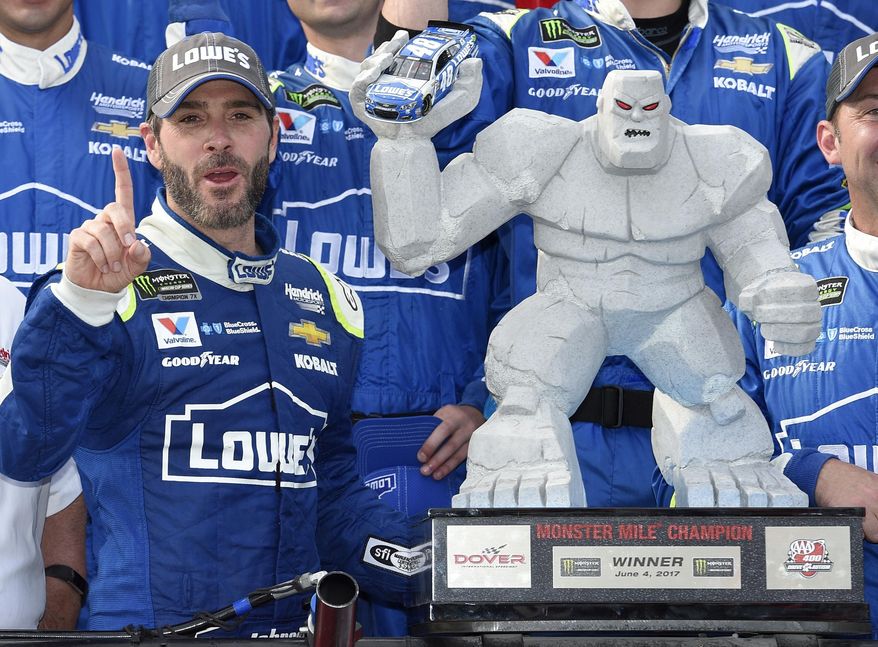 FILE - In this June 4, 2017, file photo, Jimmie Johnson, left, poses with the trophy in Victory Lane after he won a NASCAR Cup series auto race at Dover International Speedway in Dover, Del. Jimmie Johnson has a track-record 11 wins at Dover International Speedway. He’ll have to win No. 12 to guarantee a playoff spot and he has two shots this weekend when the NASCAR Cup series races on Saturday and Sunday. (AP Photo/Nick Wass, File)